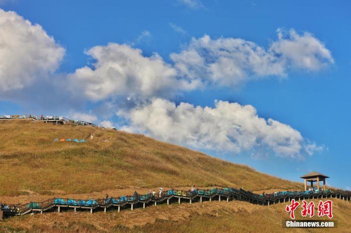 江西省の武功山の草地に設置された遊歩道を登る観光客（撮影・劉力鑫）。