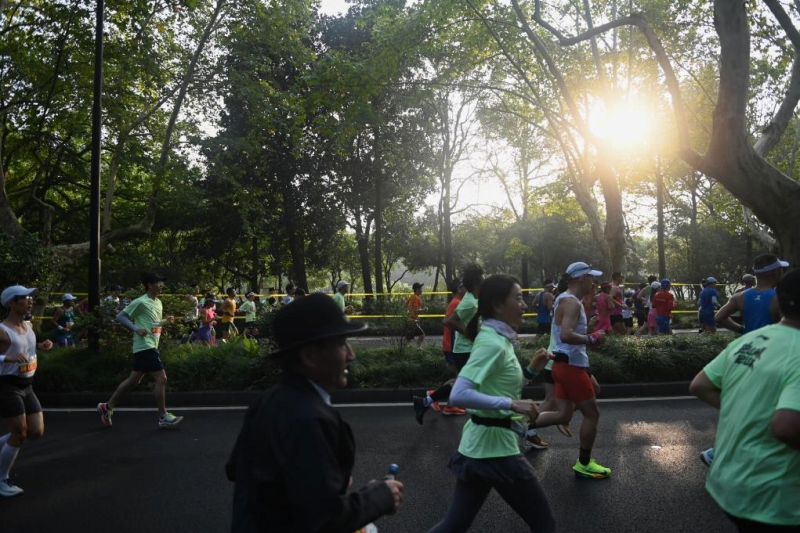 11月3日、西湖景勝地の楊公堤を走るランナー。同日、2024杭州マラソン大会が開催された。撮影・黄宗治