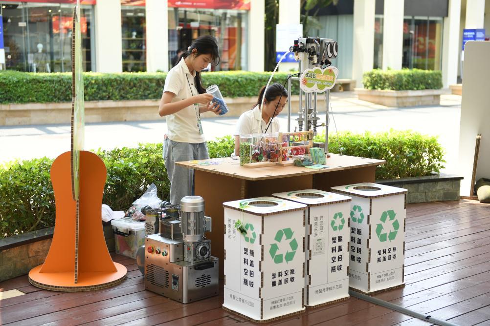 ボアオ・ゼロカーボンモデルエリアのプラスチックリサイクル工程科学展示ブースで、プラスチックのリサイクル工程を説明する職員（3月25日撮影）。撮影・謝子芸