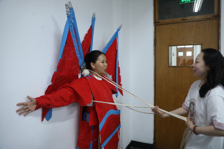 文化講座で武将役の衣装の試着を体験するモンゴル人留学生の薩仁高娃さん（写真提供・中国戯曲学院/撮影・沈欣冉）。