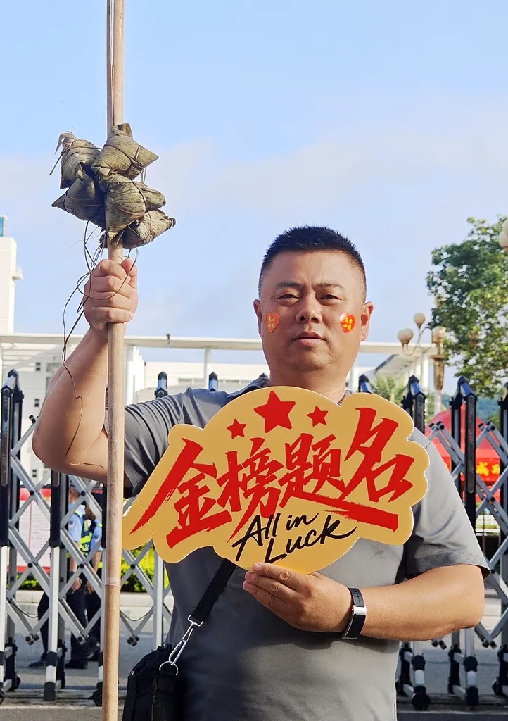 良い成績を収めるという意味の「一挙高中」にかけて「粽(中国語の「中」と発音が似ている)」を「挙」げてゲン担ぎする受験生の父親。