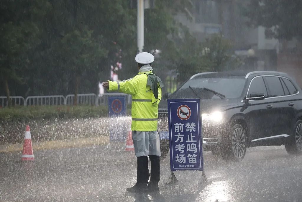 6月7日、雨天となった安徽省蕪湖市第一中学校の試験会場前で、受験生が安全に試験会場に向かうことができるよう、交通整理を行う警察官。