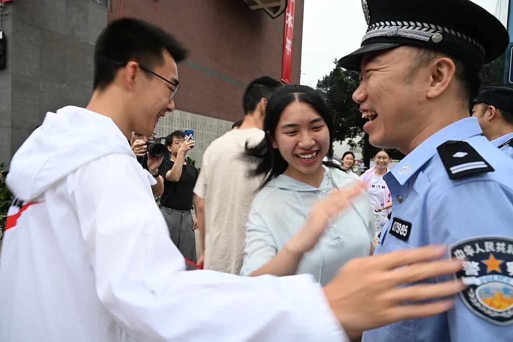 四川省の成都玉林中学校の試験会場前で、識別番号の下三桁が「985」の警察官の周りに集まる受験生。中国では中国政府が重点的に建設を進める「985プロジェクト」の対象となった大学が「985」大学と呼ばれている（6月7日撮影・張浪）。