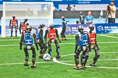5対5サッカーの試合会場では、競い合う人型ロボット。撮影・張武軍