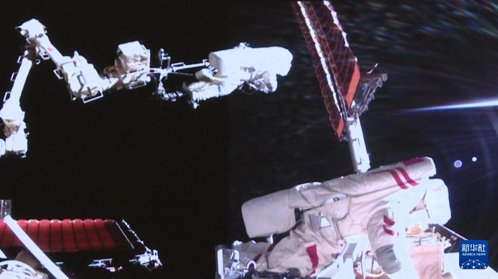 これは8月15日、北京宇宙飛行制御センターのスクリーンに映し出された、「神舟20号」の宇宙飛行士チームの陳冬氏(左)と王傑氏が船外で作業する様子(映像のスクリーンショット)。撮影・殷家捷