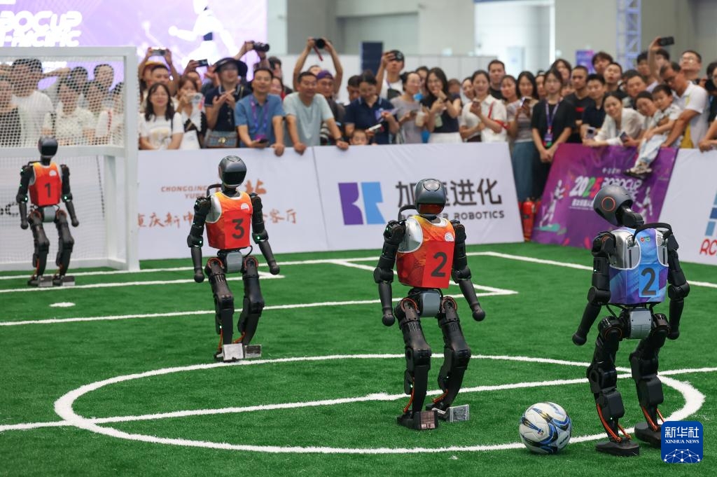 2025世界スマート産業博覧会でサッカーをする人型ロボットを見る来場者（9月5日撮影・陳誠）。