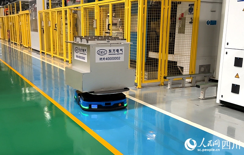 工場内で自分よりも何倍も大きい加工待ちの材料を運ぶ無人搬送車（AGV、撮影・張越）。