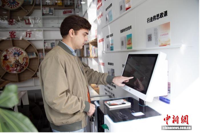 社会保障カードを使ってスマート図書館で本を借りる外国人男性（写真提供：重慶市人的資源社会保障局）。