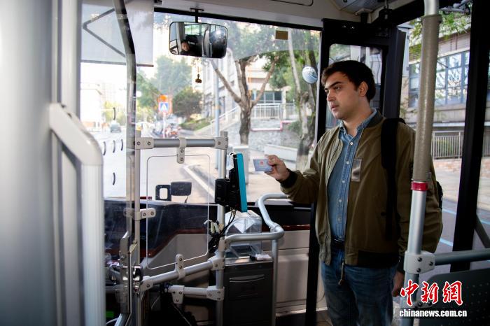 社会保障カードを使って路線バスに乗る外国人男性（写真提供：重慶市人的資源社会保障局）。