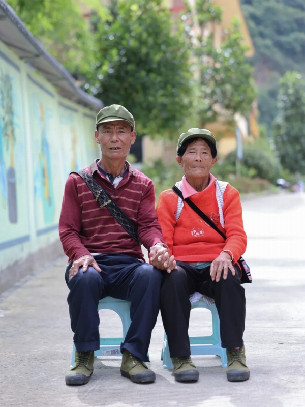 恥ずかしそうに妻の手を握り写真を撮影する相付益さん。