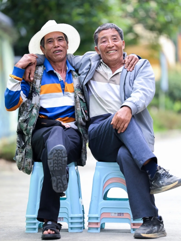 肩を組んで写真を撮影する恒鄧乃さん(写真左)と光付三さん。