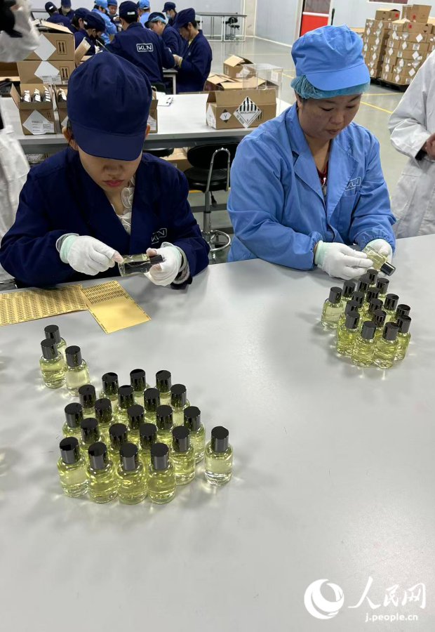 嘉順達物流有限公司内で香水のラベル貼りをする様子(撮影・玄番登史江)。