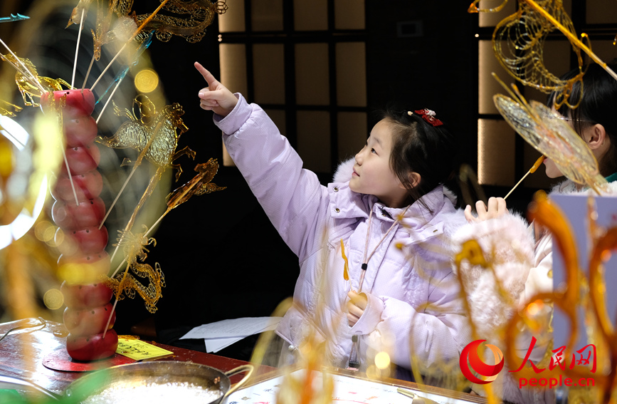 飴細工を選ぶ女の子（撮影・常力元）。