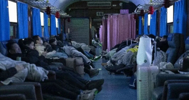 0時を過ぎて消灯され、寝たり携帯をいじったりしている旅客。