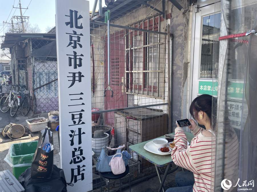 尹三豆汁店の店先で写真撮影に余念のない観光客。(撮影・勝又あや子)