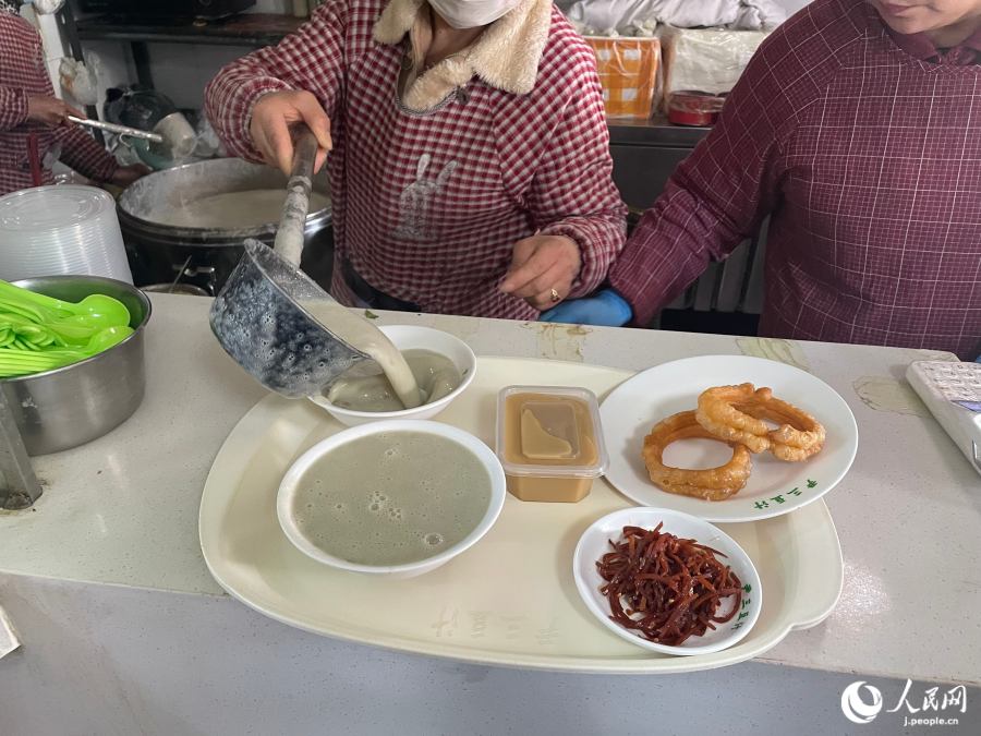 注文すると、大きなひしゃくで豆汁を注いでくれる。(撮影・勝又あや子)