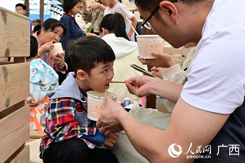 米粉を食べる男の子（撮影・雷琦竣）。