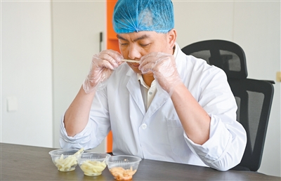 酸笋の発酵の度合いをチェックする酸笋の品質検査員である「嗅ぎ師」の李任さん。