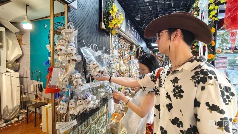 羊のぬいぐるみを選ぶ観光客（撮影・郭璁悦）。