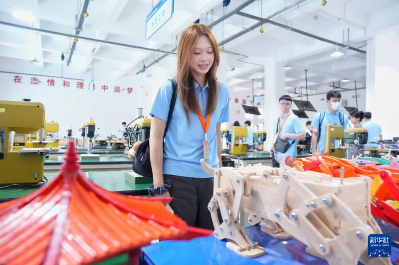 7月4日、華中テクノロジー大学工学訓練・イノベーションセンターで、学生が制作した作品を見学する台湾の若者(撮影・馬欣然)。