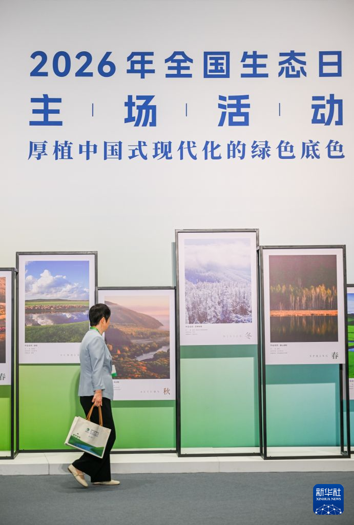 「全国生態の日」のイベントメイン会場で展示されている写真を見る来場者（8月15日撮影・連振）。