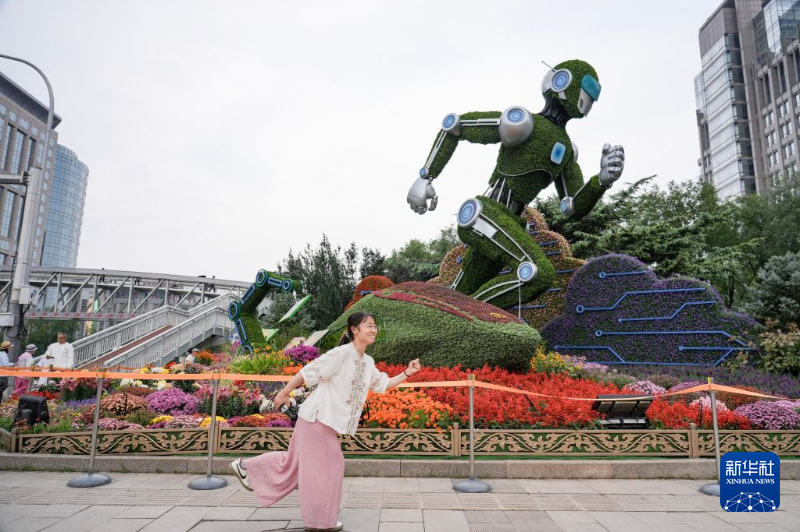 北京の東単付近で、花壇の前で記念写真を撮影する観光客（9月26日撮影・謝晗）。