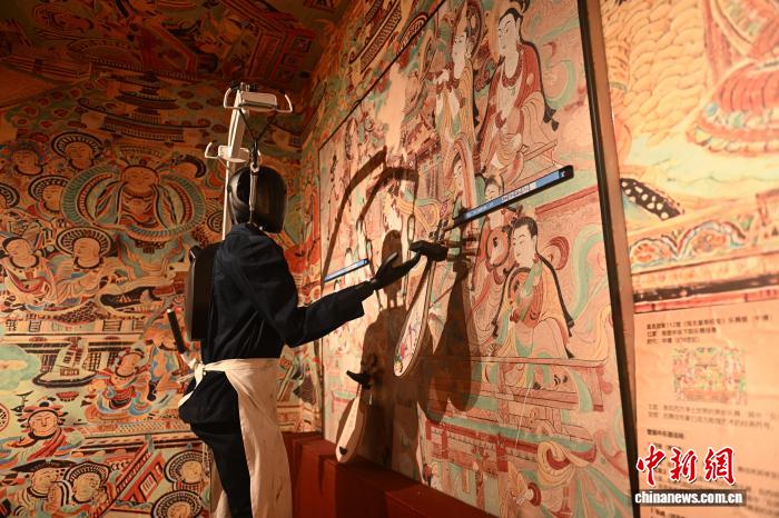 甘粛省蘭州市城関区のモバイルロボットアートトイランドで、壁画の修復のデモンストレーションを行うロボット(2月23日撮影・李亜龍)。