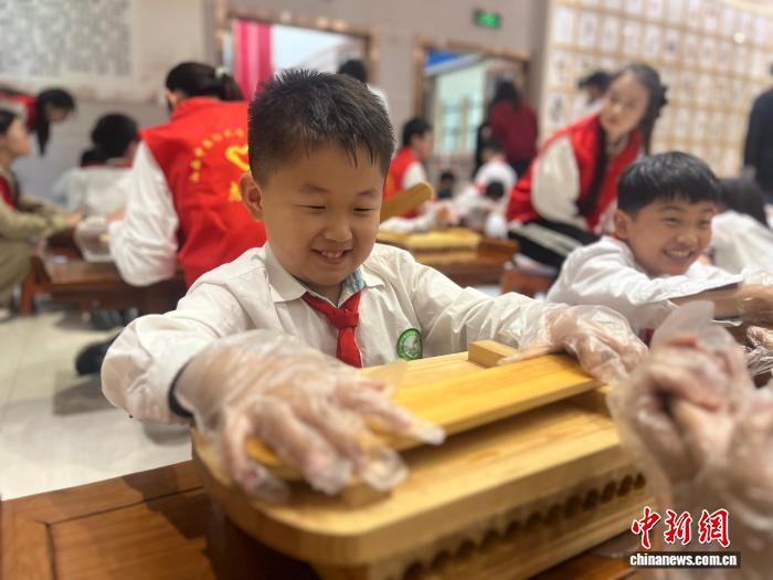 専用の道具を使って山楂丸を作る小学生たち（撮影・範麗芳）。