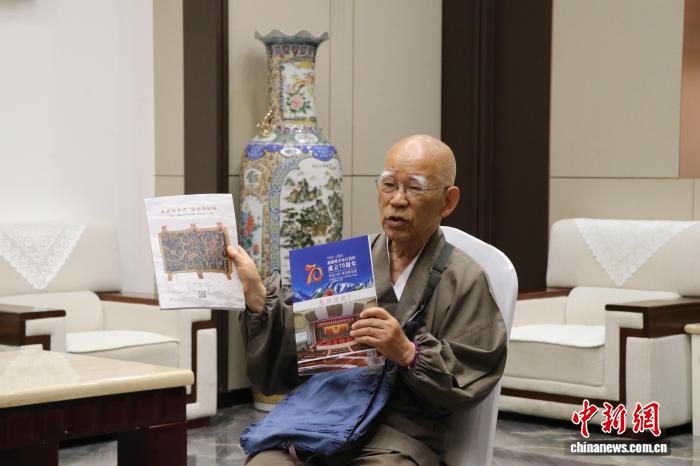 6月21日、自身が執筆した新疆関連の書籍を見せる小島康誉氏(撮影・苟継鵬)。
