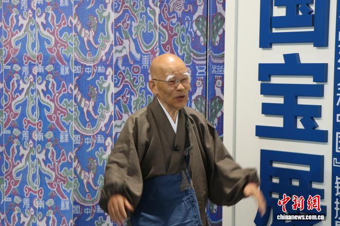 6月21日、新疆博物館で、「中華錦繍——五星出東方利中国『錦護臂国宝展』」を見学する小島康誉氏(撮影・苟継鵬)。