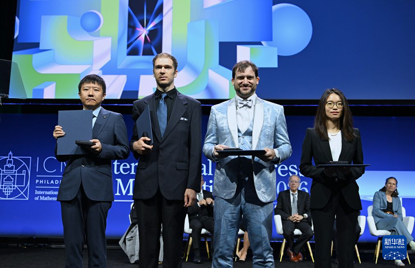 2026年国際数学者会議の開会式で記念撮影する4人のフィールズ賞受賞者。中国の数学者・鄧煜氏(写真一番左)、王虹氏(写真一番右)、米国の数学者ジョン・パードン氏(写真左から2番目)、カナダの数学者ジェイコブ・ツィマーマン氏が受賞(7月23日撮影・李睿)。